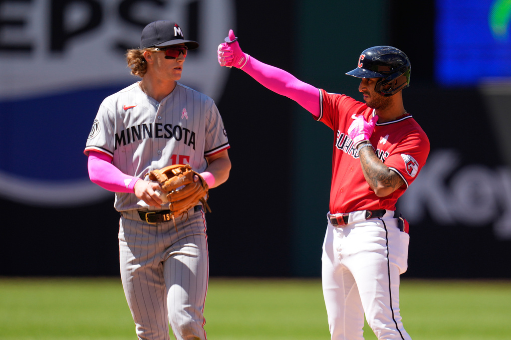Cleveland Guardians' Brayan Rocchio, right, gestues from second base next to Minnesota Twins second baseman Luke Keaschall, left, after hitting a double in the fourth inning of a baseball game in Cleveland, Sunday, May 10, 2026. (AP Photo/Sue Ogrocki)