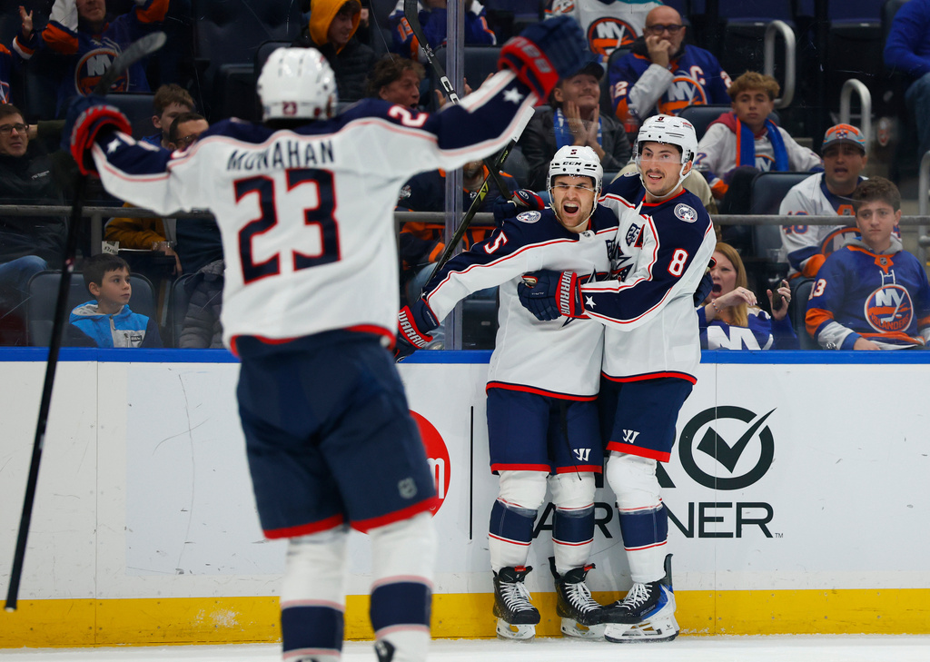 Columbus Blue Jackets defenseman Denton Mateychuk (5) celebrates with Zach Werenski (8) and Sean Monahan (23), after scoring a goal against the New York Islanders during the third period of an NHL hockey game, Sunday, Nov. 2, 2025, in New York. (AP Photo/Noah K. Murray)