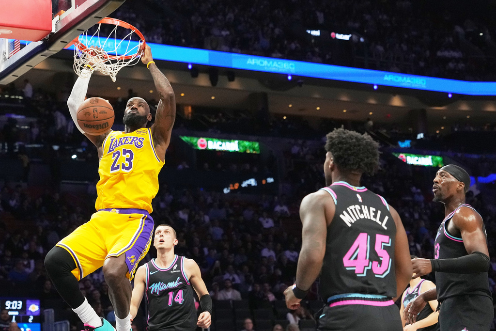 Los Angeles Lakers forward LeBron James (23) dunks over Miami Heat guard Tyler Herro (14) during the first half of an NBA basketball game, Thursday, March 19, 2026, in Miami. (AP Photo/Lynne Sladky)