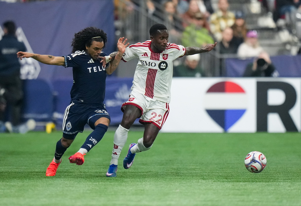 Vancouver Whitecaps' Aziel Jackson, left, and Toronto FC's Richie Laryea vie for the ball during the first half of an MLS soccer match, in Vancouver, on Saturday, Feb. 28, 2026. (Darryl Dyck/The Canadian Press via AP)