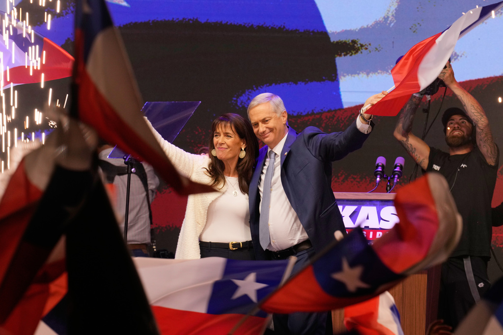 Presidential candidate Jose Antonio Kast, of the opposition Republican Party, and his wife, Maria Pia Adriasola, wave flags after winning the presidential runoff election in Santiago, Chile, Sunday, Dec. 14, 2025. (AP Photo/Matias Delacroix)