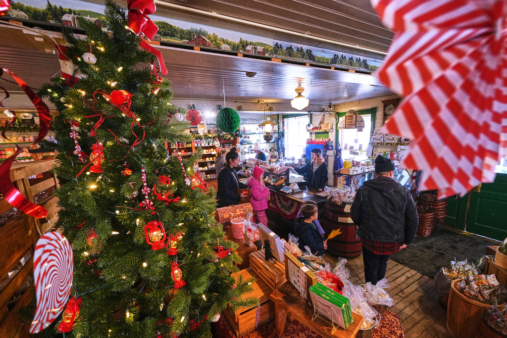 Post-holiday shoppers pass a Christmas tree at Calef's Country Store, Friday, Dec. 26, 2025, in Barrington, N.H. (AP Photo/Charles Krupa)