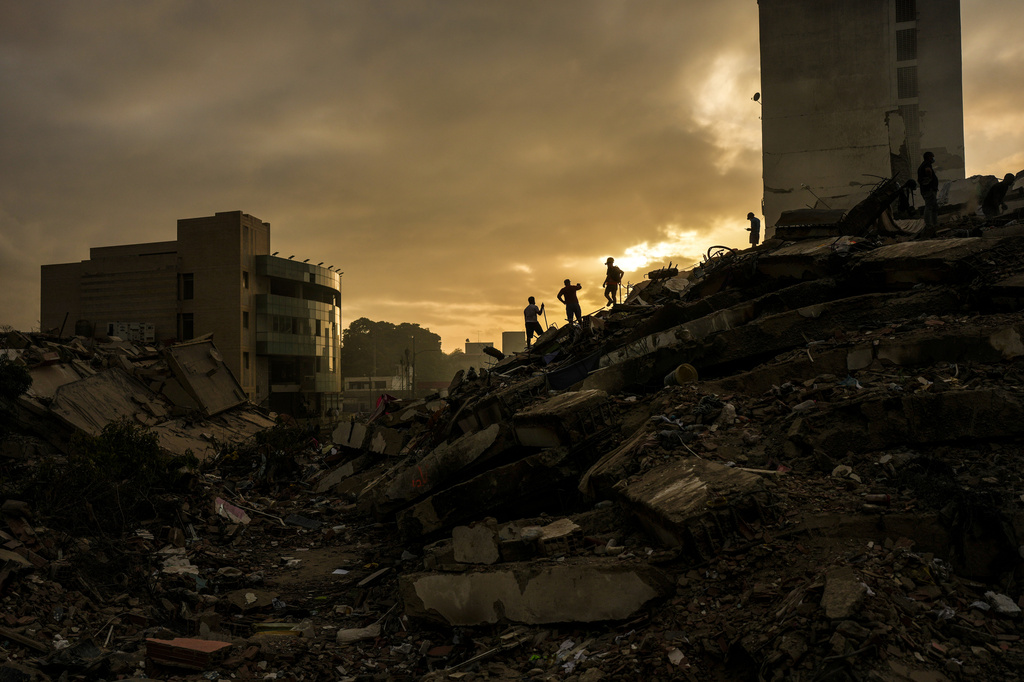 FILE - Men searching for survivors stand atop a mountain of rubble three days after twin earthquakes struck, in La Guaira, Venezuela, June 27, 2026. (AP Photo/Matias Delacroix, File)