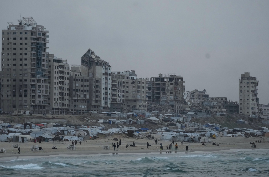 Palestinians walk by the Mediterranean beach front in Gaza City, Saturday, Dec. 6, 2025. (AP Photo/Jehad Alshrafi)