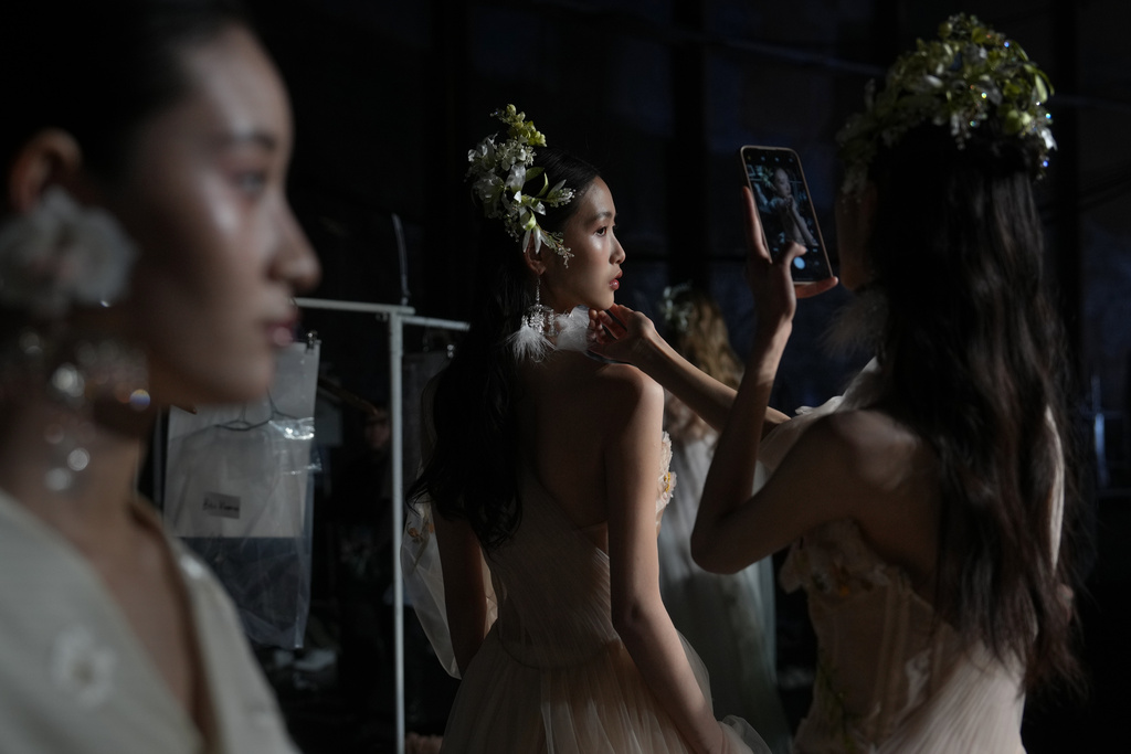 Models wear creations by Xiong Ying take a souvenir photo as they wait at backstage for the Heaven Gala Show during China Fashion Week (Spring) 2026, in Beijing, China, Friday, March 20, 2026. (AP Photo/Andy Wong)