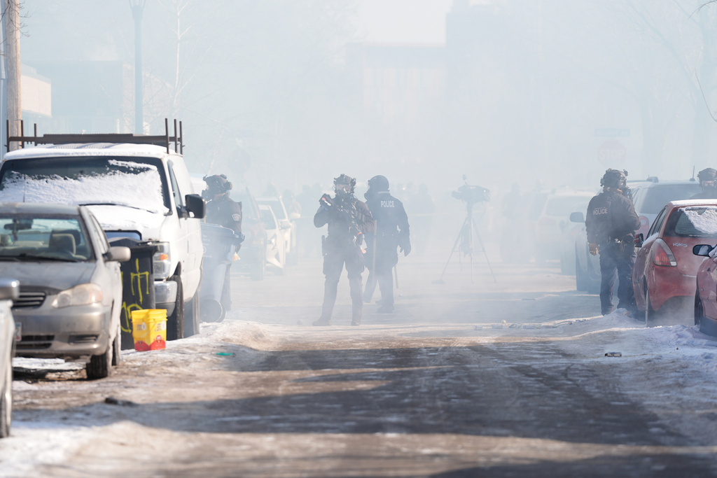 Federal immigration officers deploy tear gas at protesters after a shooting Saturday, Jan. 24, 2026, in Minneapolis. (AP Photo/Abbie Parr)