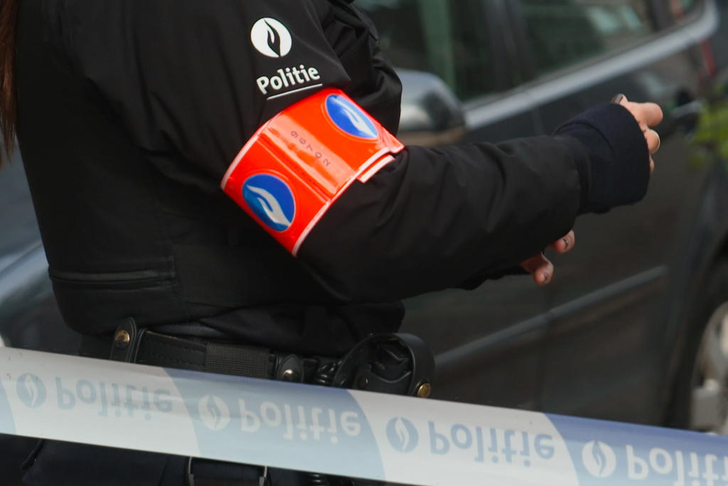 In this image taken from video provided by VTM, a police officer stands behind a cordon during an investigation in Antwerp, Belgium, Thursday, Oct. 9, 2025. (VTM via AP)