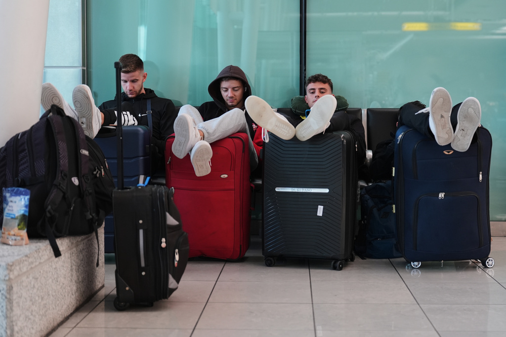 FILE - Travelers sit together and wait at the Baltimore/Washington International Thurgood Marshall Airport in Baltimore, Oct. 2, 2025. (AP Photo/Stephanie Scarbrough, File)
