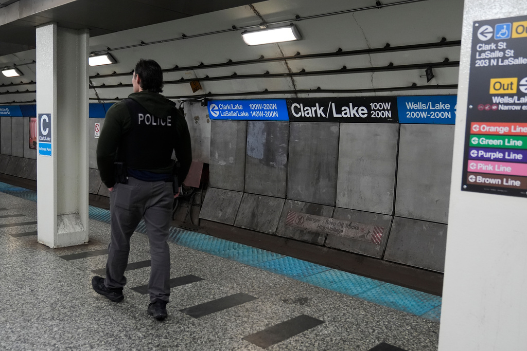 A Chicago police officer patrols the Clark Street and Lake Street Blue Line stop where a man doused a woman in liquid and set her on fire on the train Monday night, Tuesday, Nov. 18, 2025, in Chicago. (AP Photo/Erin Hooley)