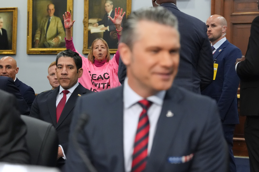 A protester interrupts as Defense Secretary Pete Hegseth arrives to testify at a House Appropriations subcommittee budget hearing for the Department of Defense, Tuesday, May 12, 2026, in Washington. (AP Photo/Alex Brandon)