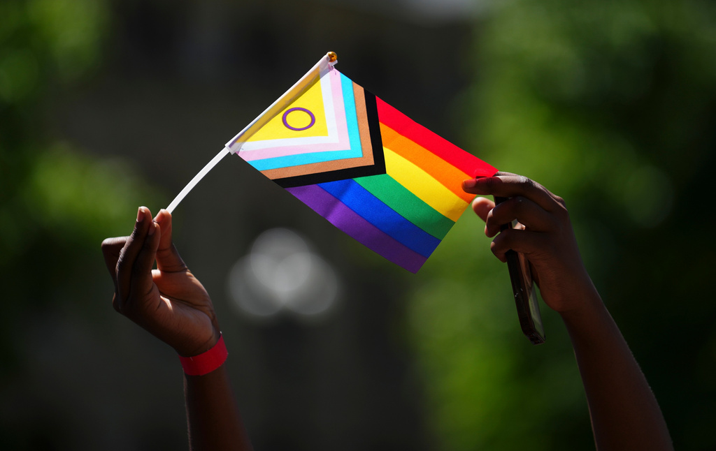 A person waves a Pride flag during a Pride flag raising ceremony on Parliament Hill in Ottawa on Tuesday, June 9, 2026. (Sean Kilpatrick/The Canadian Press via AP)