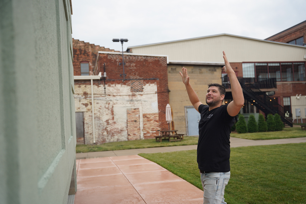 Wesley Mast, owner and president of Coppes Napanee, gestures next to a giant replica of a Hoosier cabinet in Nappanee, Ind., Thursday, Aug. 6, 2026. (AP Photo/Obed Lamy)