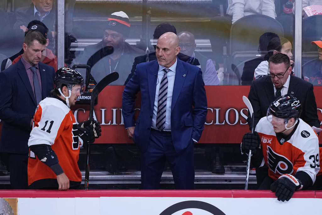 Philadelphia Flyers head coach Rick Tocchet, center, looks on from the bench during the first period of an NHL hockey game against the Florida Panthers, Monday, Oct. 13, 2025, in Philadelphia. (AP Photo/Matt Rourke)