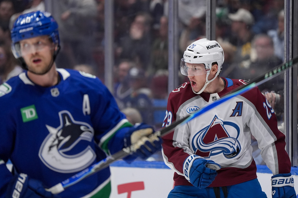 Colorado Avalanche's Nathan MacKinnon, back right, celebrates his first goal as Vancouver Canucks' Elias Pettersson skates past during the first period of an NHL hockey game in Vancouver, B.C., Sunday, Nov. 9, 2025.(Darryl Dyck/The Canadian Press via AP)