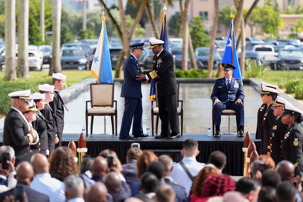 Navy Adm. Alvin Holsey, center, shakes hands with Gen. Dan Caine, chairman of the Joint Chiefs of Staff, during a relinquishment of command and retirement ceremony, handing over command to Air Force Lt. Gen. Evan Pettus, right, at U.S. Southern Command, Friday, Dec. 12, 2025, in Doral, Fla. (AP Photo/Rebecca Blackwell)