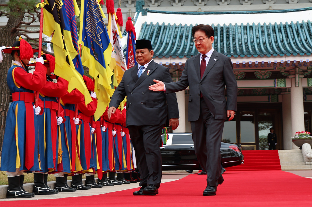 Indonesian President Prabowo Subianto, left, and South Korean President Lee Jae Myung walk toward for the welcoming ceremony at presidential office in Seoul, South Korea, Wednesday, April 1, 2026. (Kim Do-hun/Yonhap via AP)
