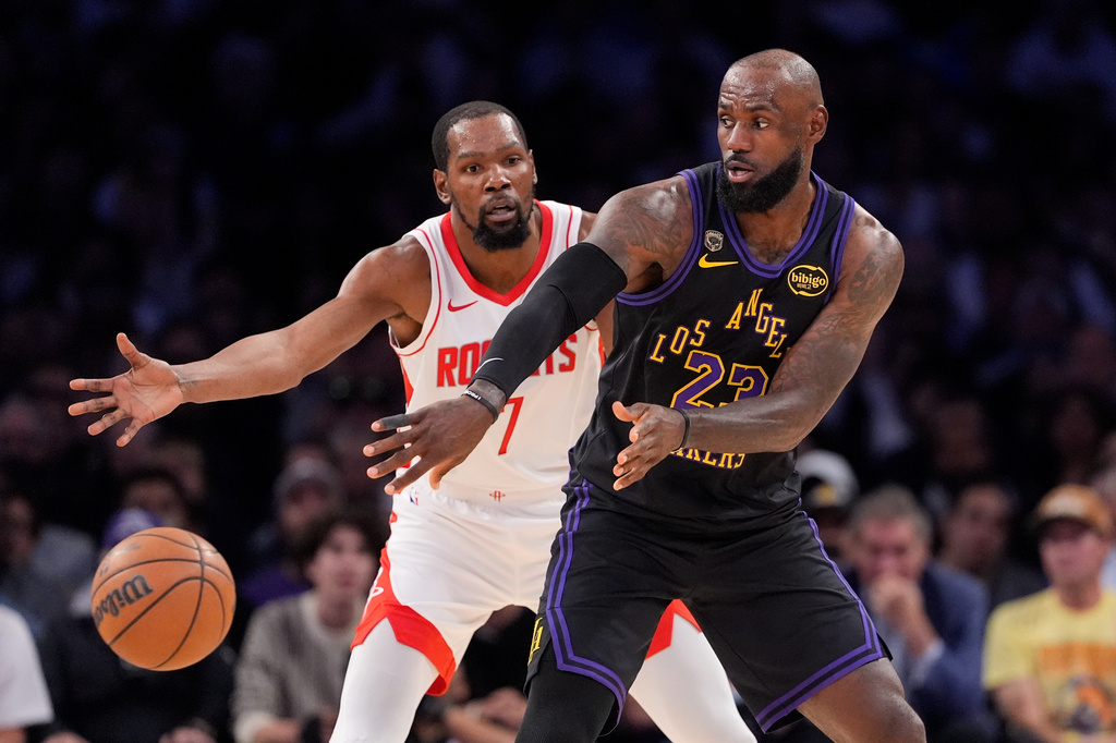 Los Angeles Lakers forward LeBron James, right, passes the ball while under pressure from Houston Rockets forward Kevin Durant during the first half in Game 2 of a first-round NBA playoffs basketball series Tuesday, April 21, 2026, in Los Angeles. (AP Photo/Mark J. Terrill)