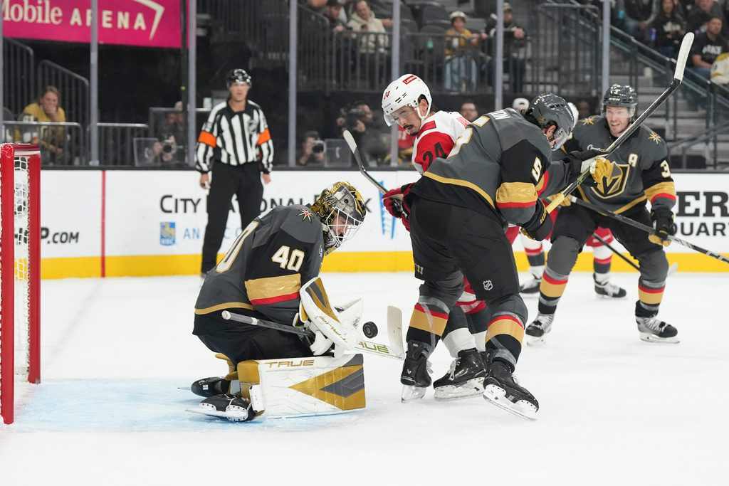 Vegas Golden Knights goaltender Akira Schmid (40) stops a shot by the Carolina Hurricanes during the first period of an NHL hockey game Monday, Oct. 20, 2025, in Las Vegas. (AP Photo/Candice Ward)