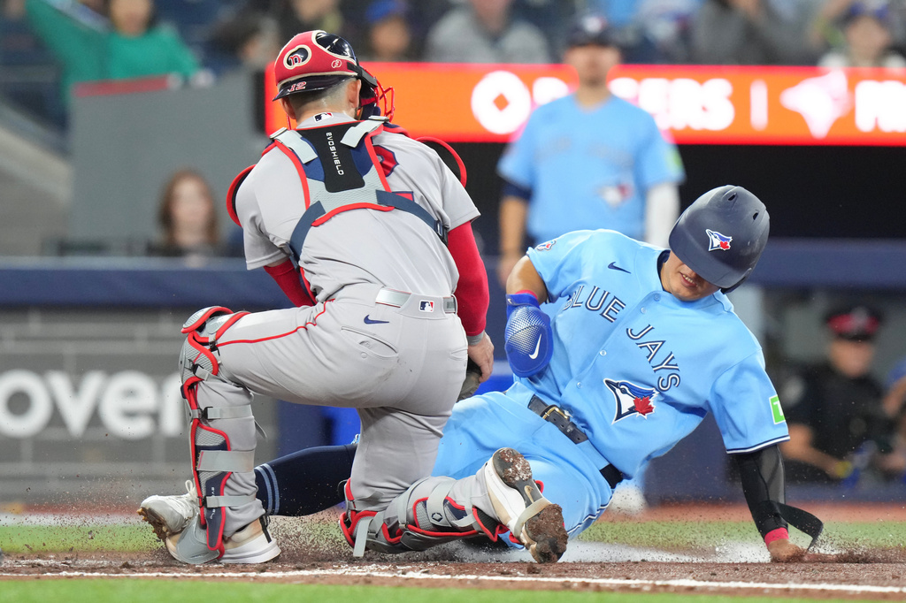 Toronto Blue Jays' Kazuma Okamoto (7) is tagged out at the plate by Boston Red Sox catcher Connor Wong (12) after an RBI single by Toronto Blue Jays' Yohendrick Pinango (24) during the third inning of a baseball game in Toronto, Wednesday, April 29, 2026. (Chris Young/The Canadian Press via AP)