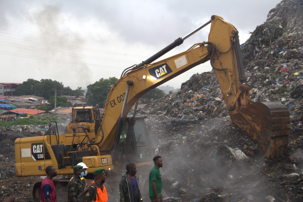 Rescue workers search through a heap of refuse after it collapsed at Conakry’s largest landfill, Guinea, Sunday, Aug. 23, 2026. (AP Photo/Fodo Toure)