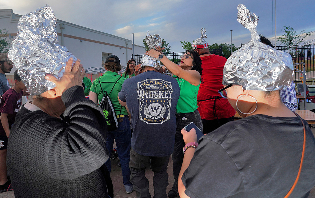 FILE - Attendees playfully wear tin foil hats at the Edinburg UFO Festival, April 5, 2024, in Edinburg, Texas. (Joel Martinez/The Monitor via AP, File)
