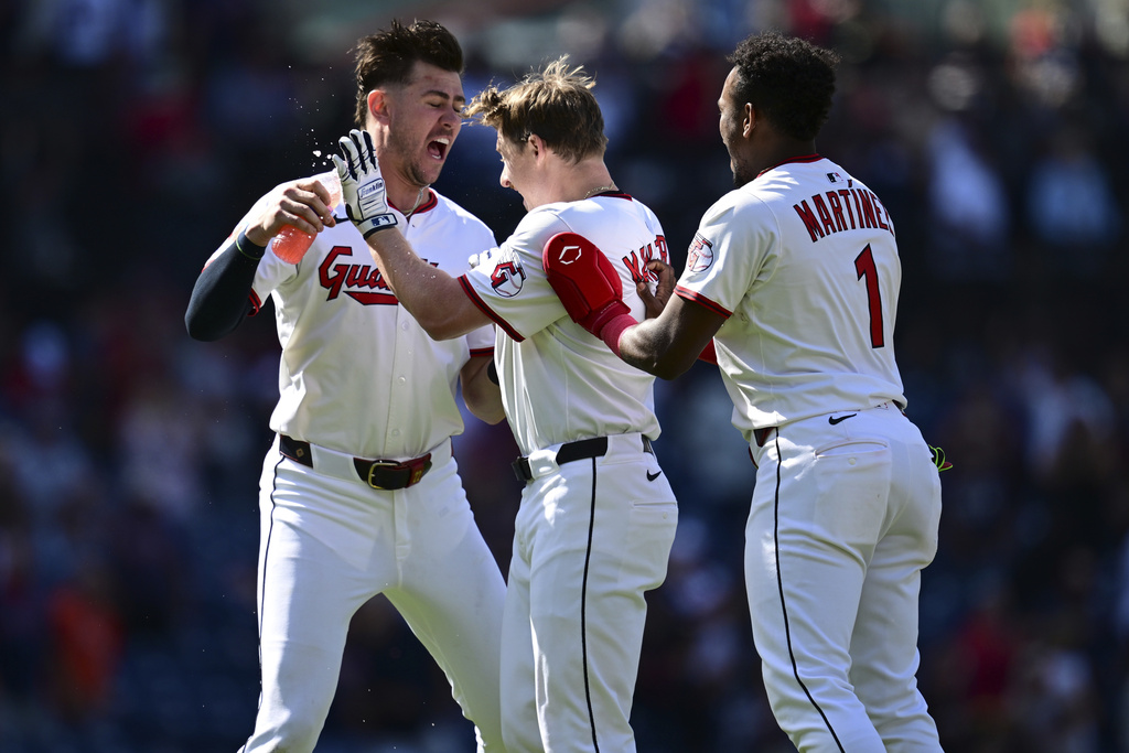 Cleveland Guardians' Kyle Manzardo, center, is congratulated by Angel Martinez, right, and Nolan Jones, left, after driving in the game winning run in the 10th inning of a baseball game against the Tampa Bay Rays, Wednesday, Aug. 27, 2025, in Cleveland. (AP Photo/David Dermer)