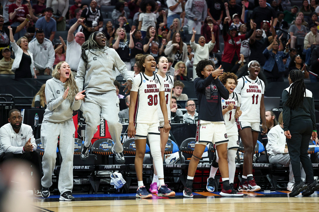 The South Carolina bench celebrates after guard Agot Makeer, not shown, makes a layup during the second half in the Elite Eight of the NCAA college basketball tournament against TCU Monday, March 30, 2026, in Sacramento, Calif. (AP Photo/Sara Nevis)