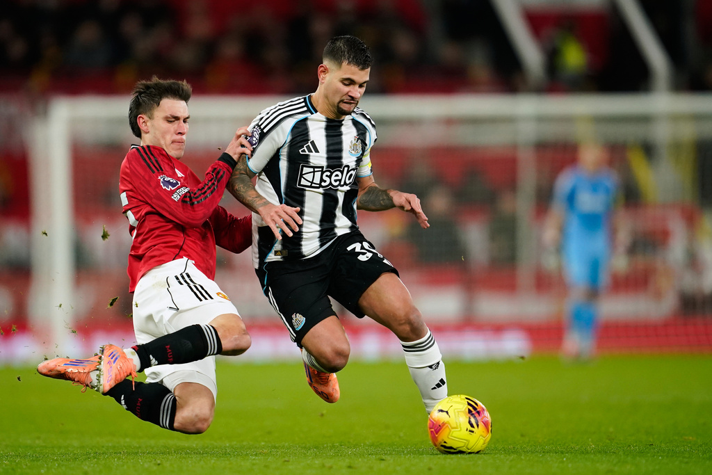Manchester United's Manuel Ugarte, left, fights for the ball with Newcastle's Bruno Guimaraes during the English Premier League soccer match between Manchester United and Newcastle in Manchester, England, Friday, Dec. 26, 2025. (AP Photo/Dave Thompson)