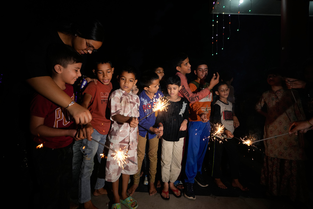 Children play with firecrackers on Diwali festival, the Hindu festival of lights, at an orphanage in Jammu, India, Sunday, Oct. 19, 2025. (AP Photo/Channi Anand)