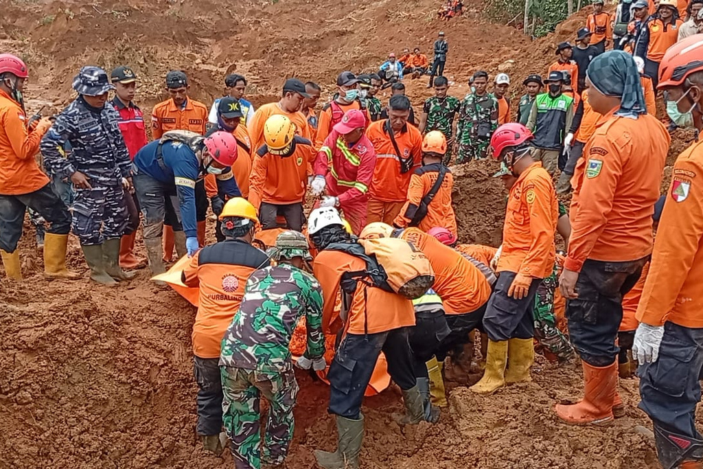 In this photo released by the Indonesian National Search and Rescue Agency (BASARNAS) on Monday, Nov. 17, 2025, rescuers recover a victim of a landslide in Cilacap, Indonesia. (BASARNAS via AP)