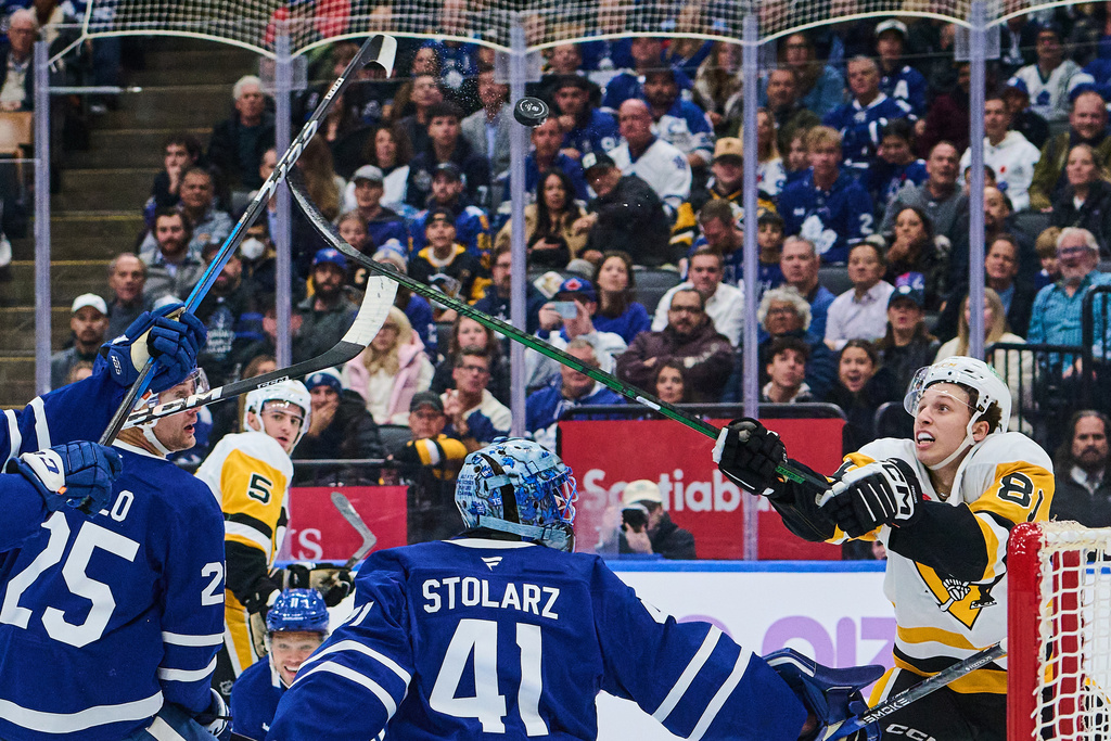 Pittsburgh Penguins' Ben Kindel (81) reaches for the puck above Toronto Maple Leafs goaltender Anthony Stolarz (41) to score during first period NHL hockey action in Toronto, on Monday, Nov. 3, 2025. (Sammy Kogan/The Canadian Press via AP)