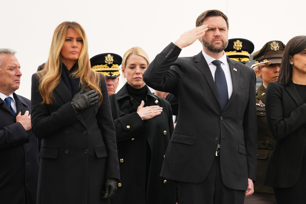 Attorney General Pam Bondi is seen standing between first lady Melania Trump and Vice President JD Vance during a casualty return for the soldiers who were killed in a drone strike at a command center in Kuwait after the U.S. and Israel launched its military campaign against Iran, Saturday, March 7, 2026, at Dover Air Force Base, Del. (AP Photo/Julia Demaree Nikhinson)