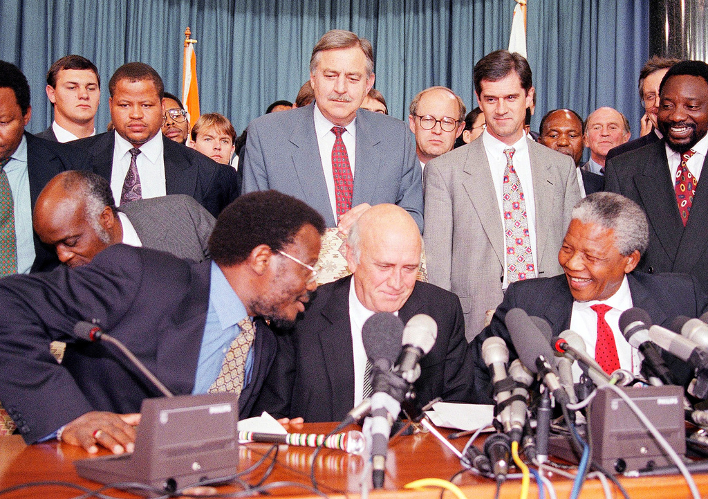 FILE - This April 19, 1994 file photo shows in the front row; Inkatha Freedom Party (IFP) Chief Mangosuthu Buthelezi, left, President F.W. de Klerk, middle, and African National Congress (ANC) President Nelson Mandela, right, exchanging words at a news conference, while in the back row at center South African Foreign Minister Pik Botha looks over them, in Pretoria, South Africa. Next to Botha, second from right is Roelf Meyer, chief government negotiator, and ANC's Secretary General Cyril Ramaphosa, right. (AP Photo/Lynne Sladky, File)