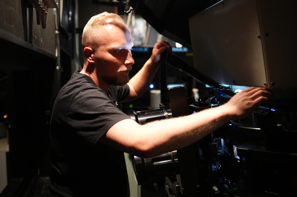 Tomas Vysinsky prepares the 70 mm IMAX copy of Christopher Nolan's "The Odyssey" for screening in Prague, Czech Republic, Monday, July 27, 2026. (AP Photo/Petr David Josek)
