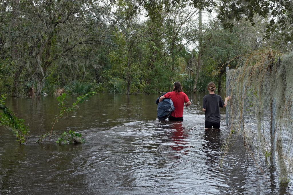 FILE - Connor Hughes and Kaylee Swenson walk through floodwaters from the Alafia River caused by Hurricane Milton, Oct. 11, 2024, in Lithia, Fla. (AP Photo/Chris O'Meara, File)
