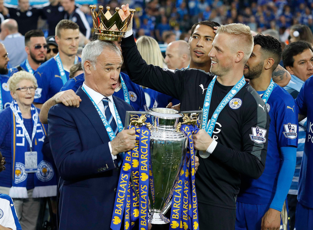 FILE - Leicester City team manager Claudio Ranieri has the crown of the trophy placed on his head by Leicester goalkeeper Kasper Schmeichel as they celebrate becoming the English Premier League soccer champions at King Power stadium in Leicester, England, May 7, 2016. (AP Photo/Matt Dunham, File)