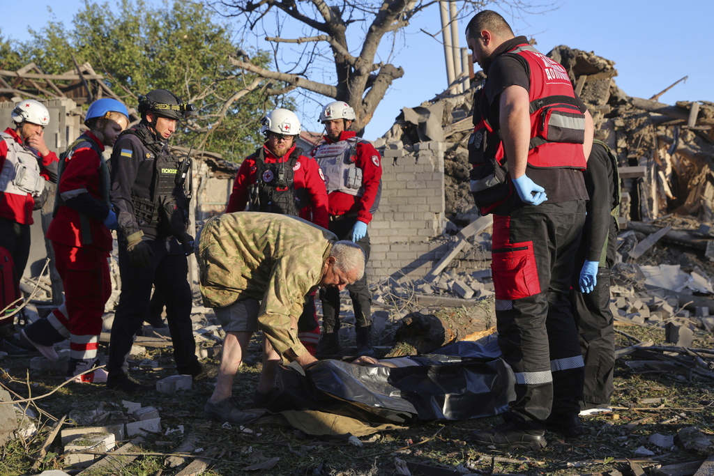 A relative, center, mourns by a dead body after a Russian strike in Zaporizhzhia, Ukraine, Monday, Sept. 22, 2025. (AP Photo/Kateryna Klochko)