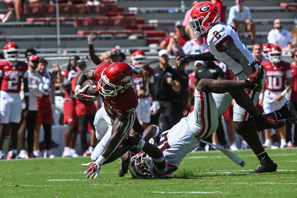Arkansas wide receiver Jamari Hawkins, left, is tackled by Georgia defensive back Ja'Marley Riddle, center, during the second half of an NCAA college football game Saturday, Sept. 19, 2026, in Fayetteville, Ark. (AP Photo/Michael Woods)