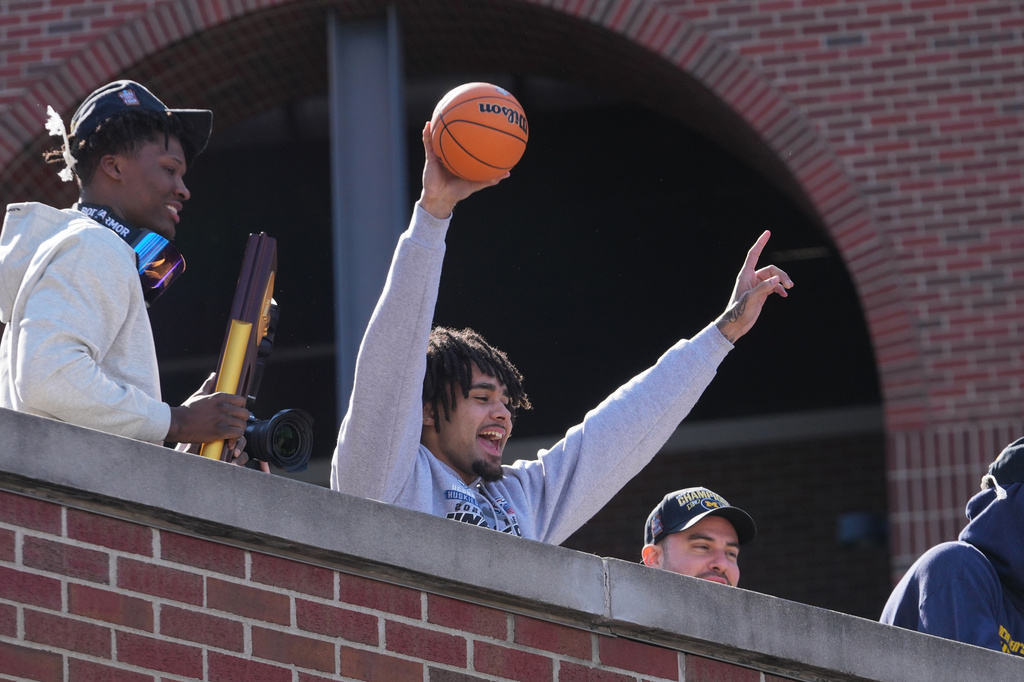 Michigan's Elliot Cadeau celebrates with fans upon returning to campus Tuesday, April 7, 2026, in Ann Arbor, Mich., the day after defeating UConn at the Final Four of the NCAA college basketball tournament. (AP Photo/Paul Sancya)