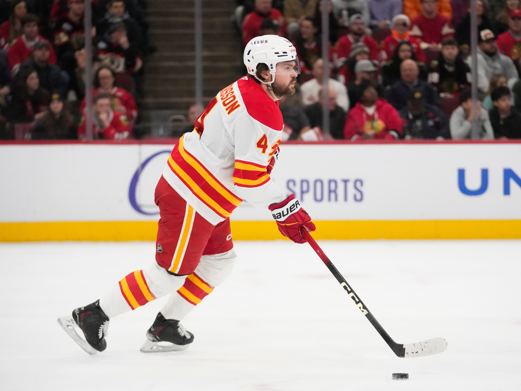 Calgary Flames defenseman Rasmus Andersson (4) handles the puck during the first period of an NHL hockey game against the Chicago Blackhawks, Thursday, Jan. 15, 2026, in Chicago. (AP Photo/Erin Hooley)