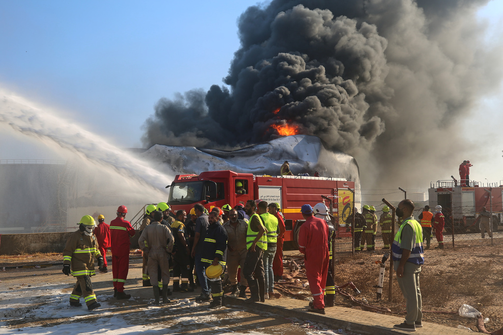 Firefighters work to contain a fire at the Zawiya oil refinery following a drone strike in Zawiya, Libya, Tuesday, Aug. 11, 2026. (AP Photo/Yousef Murad)