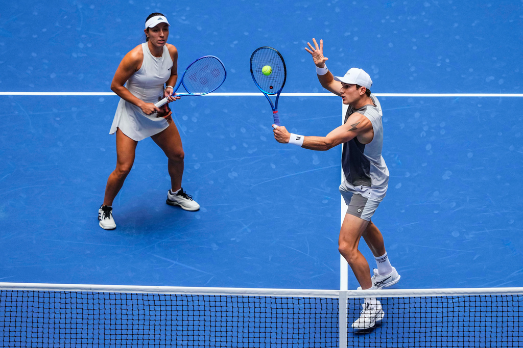 Jack Draper, right, of United States, plays a shot as partner Jessica Pegula, of United States, covers during their mixed doubles match at the U.S. Open tennis championships, Tuesday, Aug. 19, 2025, in New York. (AP Photo/Yuki Iwamura)