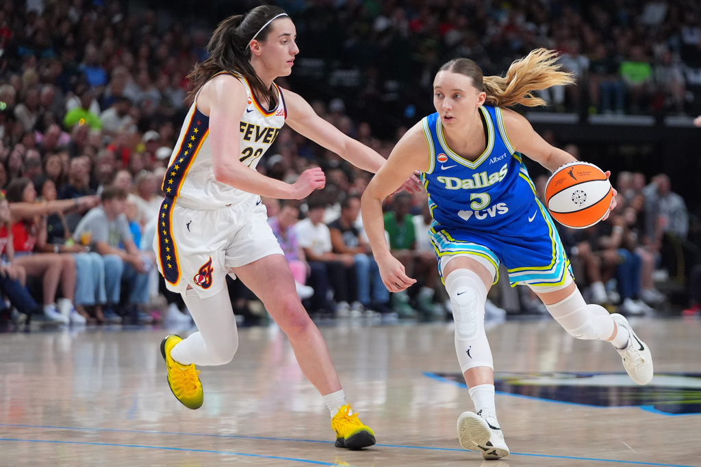 Dallas Wings guard Paige Bueckers, right, drives against Indiana Fever guard Caitlin Clark, left, during the first half of a WNBA basketball game in Dallas, Thursday, Aug. 20, 2026. (AP Photo/LM Otero)