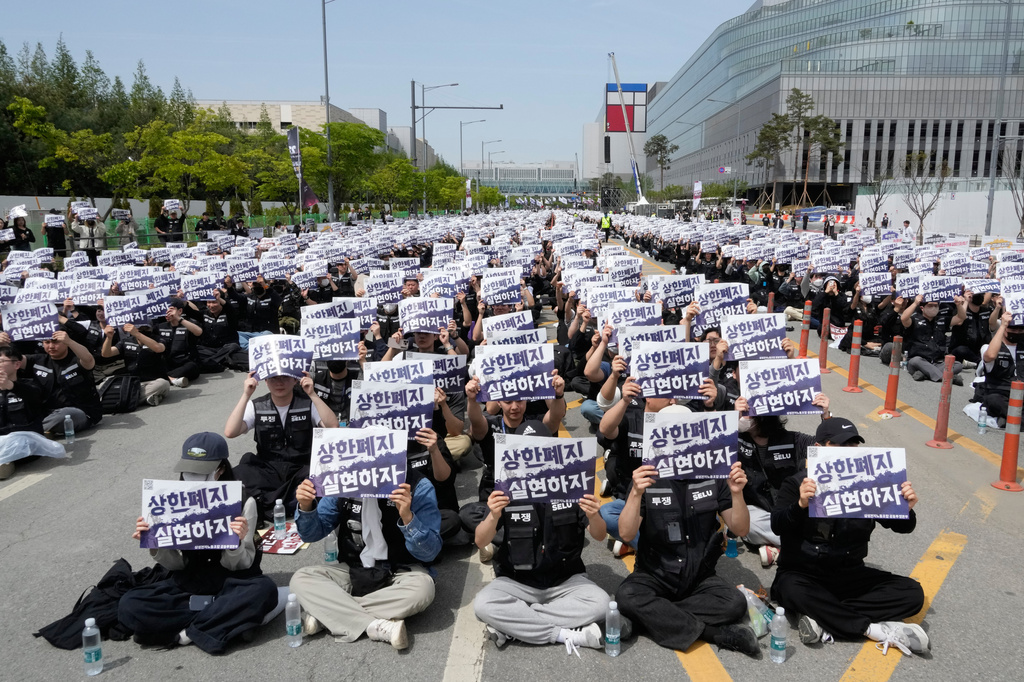 Members of the Samsung Electronics labor union hold up their cards during a rally demanding higher bonuses at its computer chip complex in Pyeongtaek, South Korea, Thursday, April 23, 2026. The letters read "Remove the bonuses caps." (AP Photo/Ahn Young-joon)