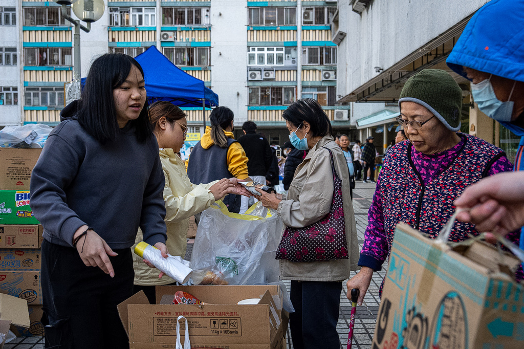 Volunteers distribute donated supplies following the fire that started Wednesday at Wang Fuk Court, a residential estate in the Tai Po district of Hong Kong's New Territories, Friday, Nov. 28 2025. (AP Photo/Chan Long Hei)