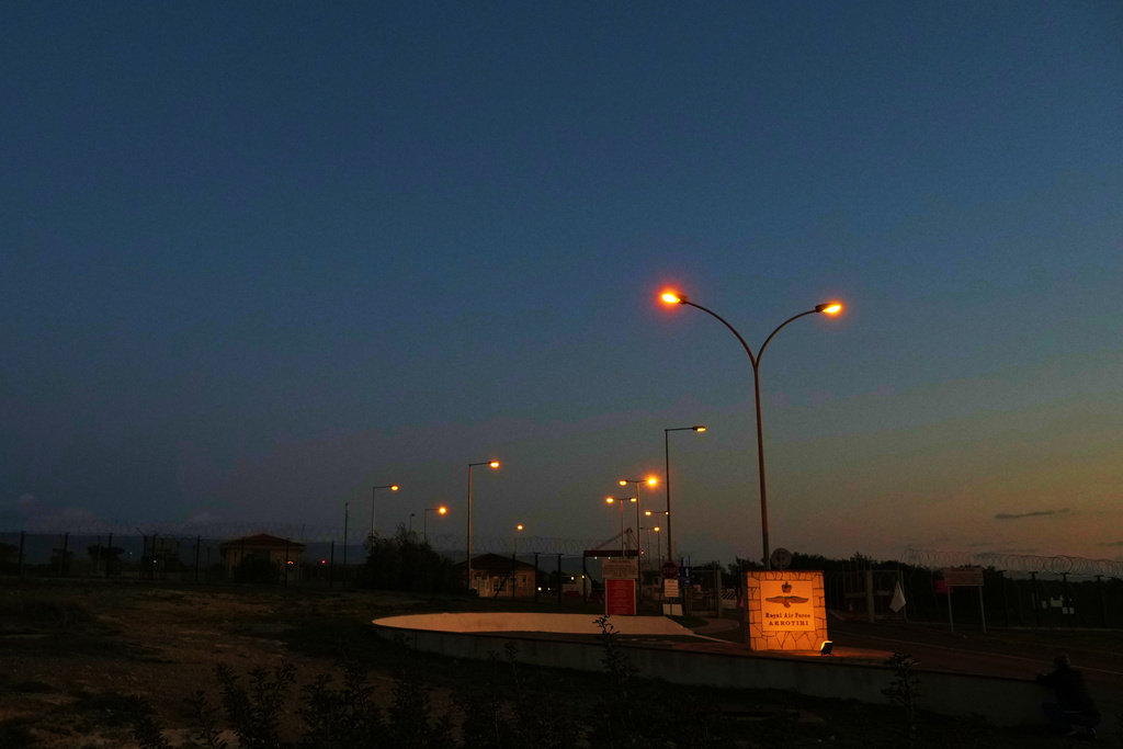 FILE - The gate of the U.K.'s RAF Akrotiri air base at sunset after it was struck by a drone earlier in the morning near Limassol, Cyprus, March 2, 2026. (AP Photo/Petros Karadjias, File)
