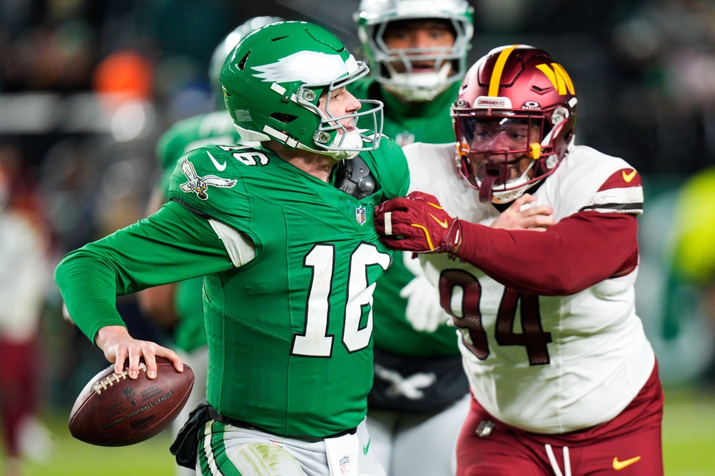 Philadelphia Eagles quarterback Tanner McKee (16) looks to pass while under pressure from Washington Commanders defensive tackle Daron Payne (94) during the second half of an NFL football game Sunday, Jan. 4, 2026, in Philadelphia. (AP Photo/Chris Szagola)