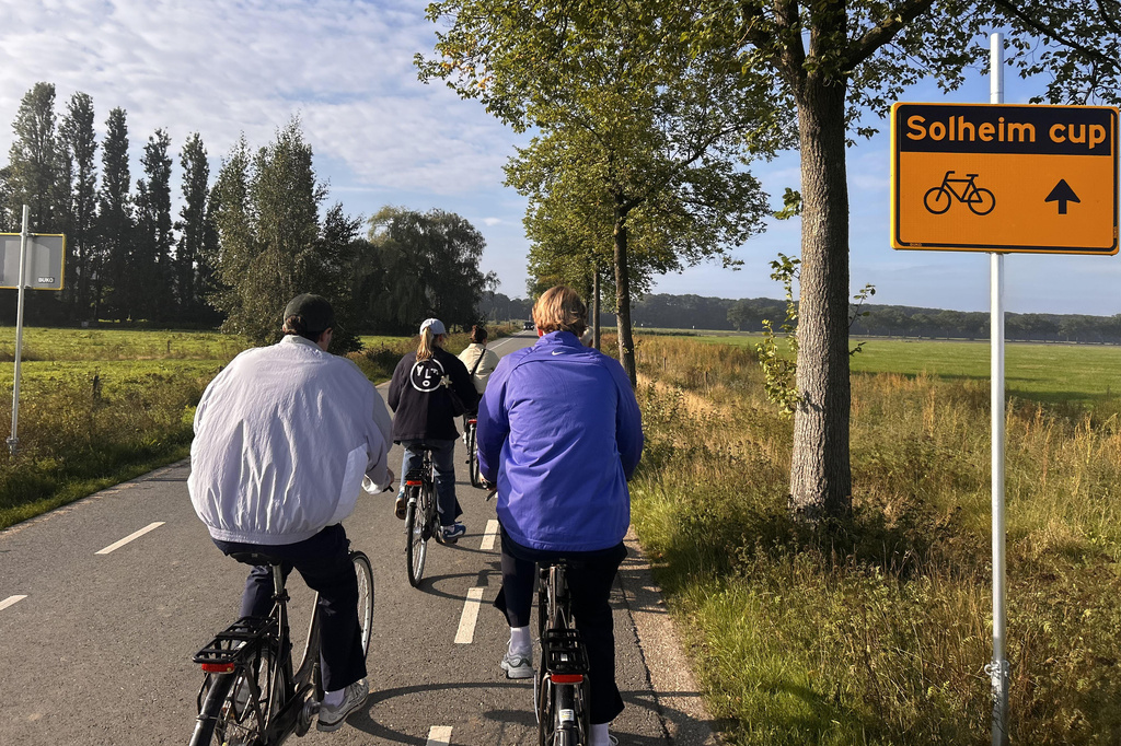 In this photo taken with a smartphone, people cycle along the route signposted toward the Solheim Cup venue, Bernardus Golf in Den Bosch, Netherlands, Saturday Sept. 12, 2026. (AP Photos/Mike Corder)