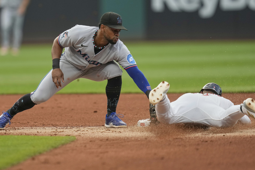 Cleveland Guardians' Brayan Rocchio, right, slides under the tag of Miami Marlins shortstop Otto Lopez, left, to steal second base in the second inning of a baseball game in Cleveland, Tuesday, Aug. 12, 2025. (AP Photo/Sue Ogrocki)
