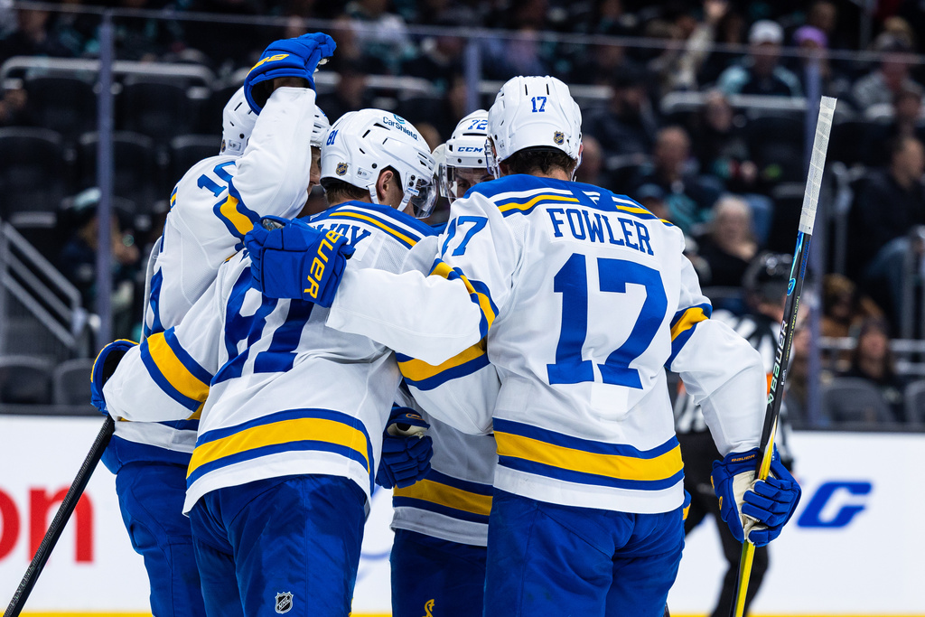 St. Louis Blues left wing Dylan Holloway (81) and defenseman Cam Fowler (17) celebrate with teammates after goal by Holloway and an assist to Fowler during the second period an NHL hockey game against the Seattle Kraken, Wednesday, March 4, 2026, in Seattle. (AP Photo/Maddy Grassy)